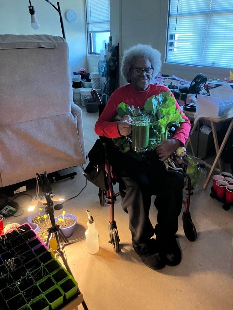 Nana with a green smoothie and a bundle of greens