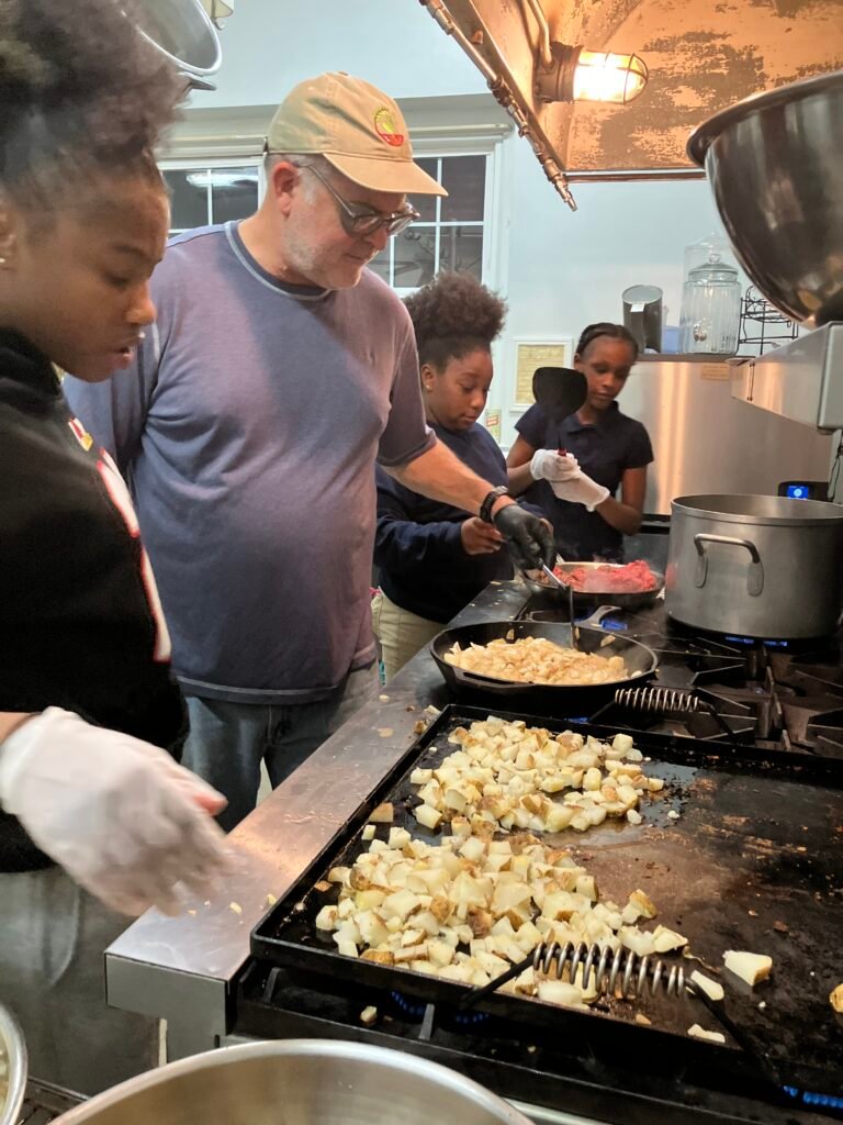 Volunteers and young cooks making burritos