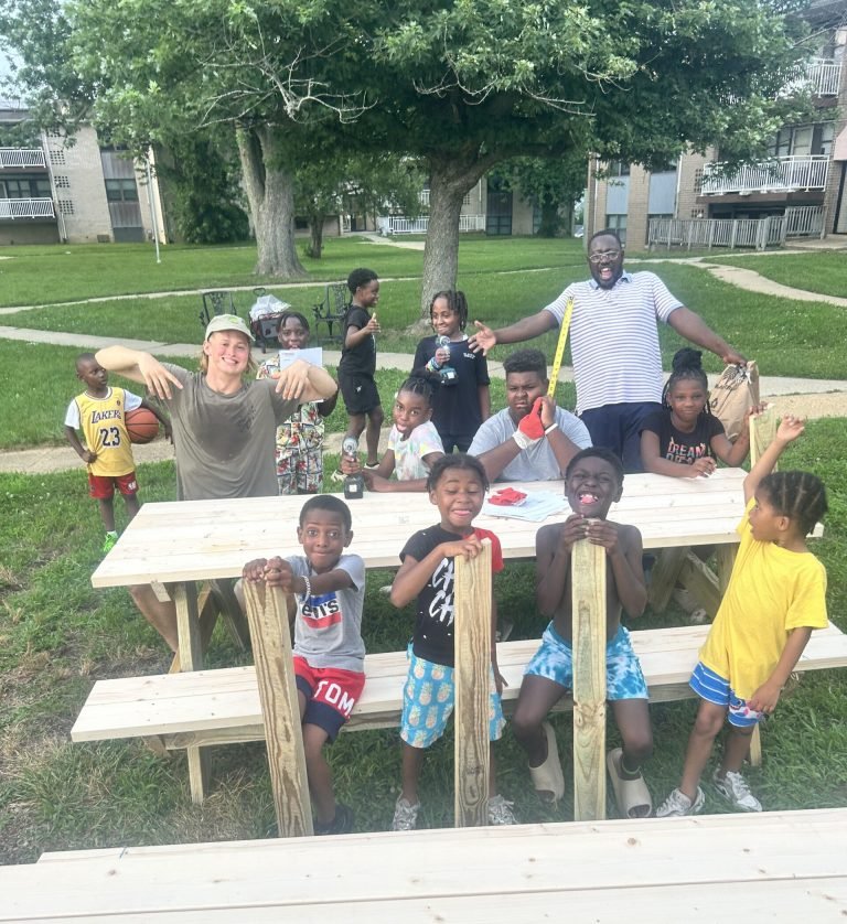 Kids with the picnic tables they built