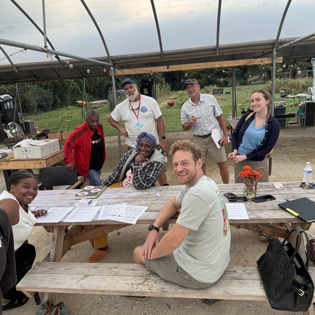 Joy Grows board and team at the October 2026 board meeting in the greenhouse at Eastport Community Farm