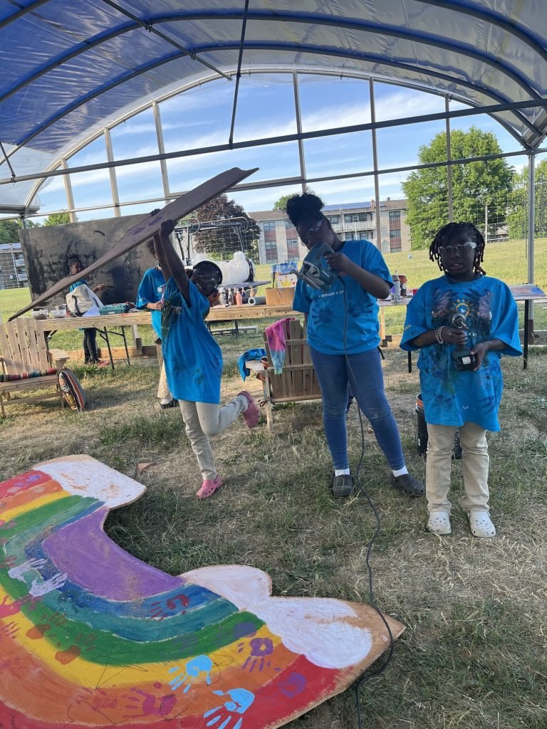 Art Club painting a rainbow in the greenhouse to get ready for the ribbon cutting