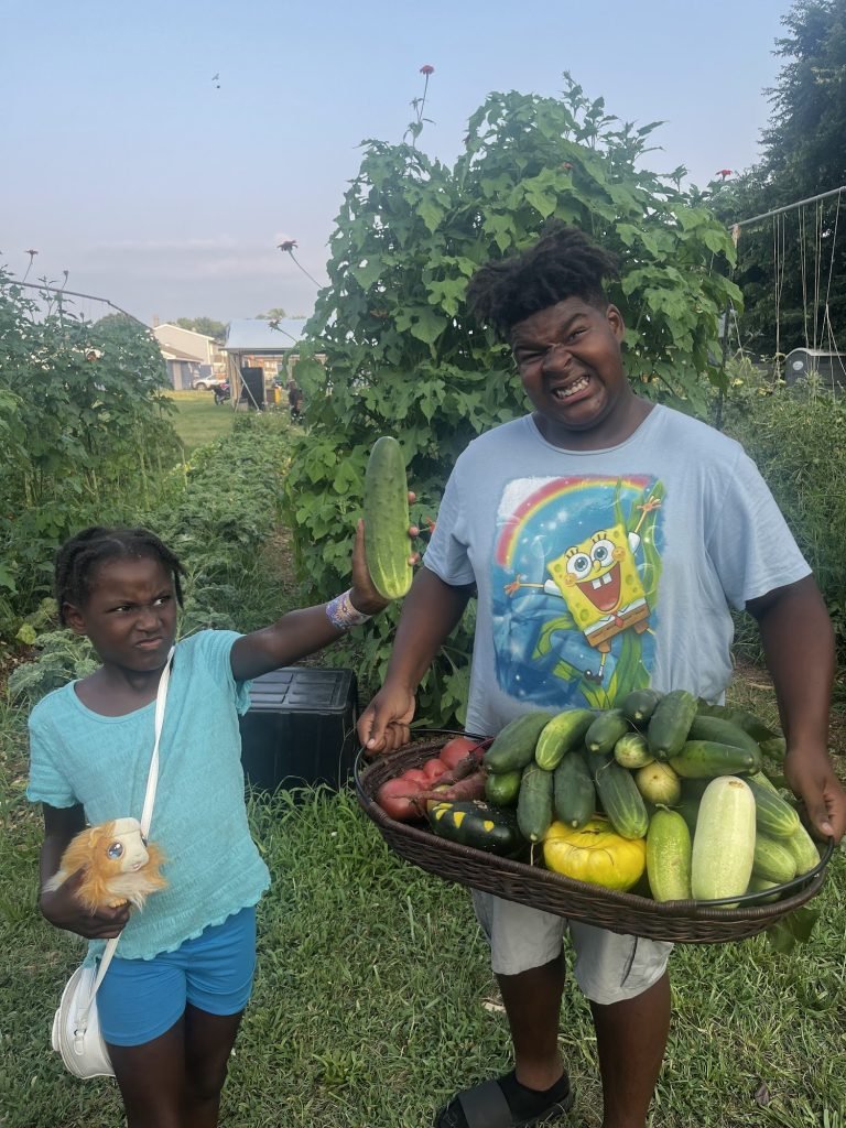 Rayell and Damari with a huge cucumber harvest