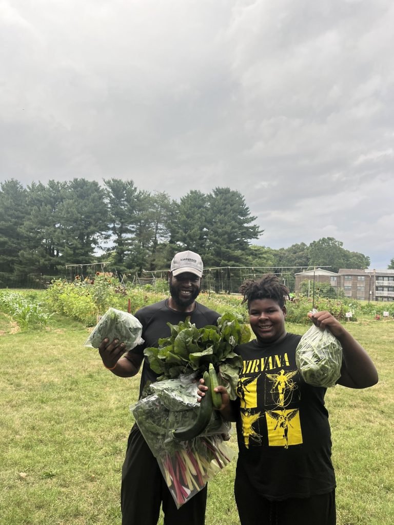 Damari and Kareem with a harvest pulled from the field