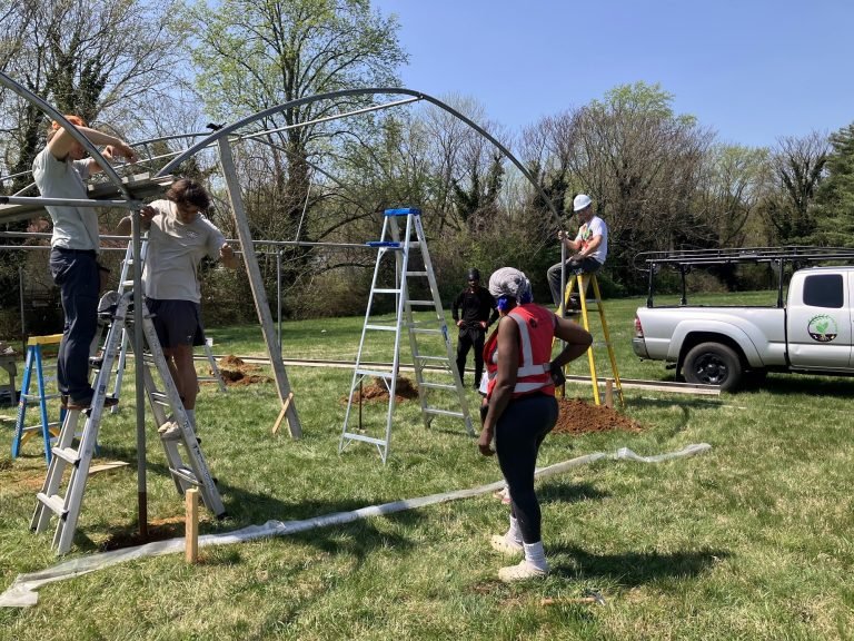 The building team putting up the greenhouse frame