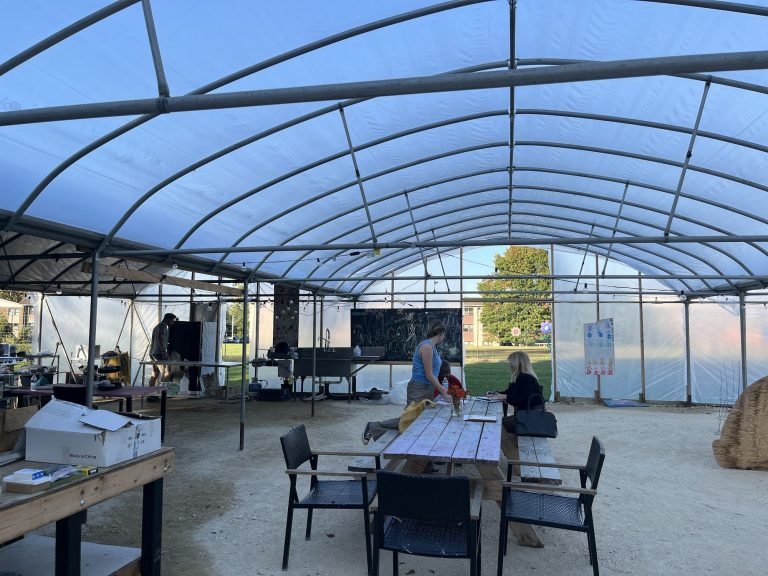 Inside the greenhouse, with the sink, chalkboard and picnic tables