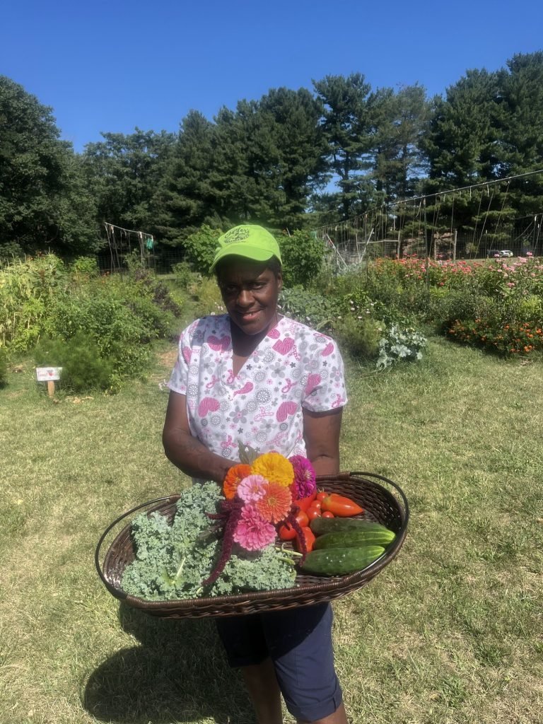 Ms. Peaches (Donna Johnson) with a basket of produce from the farm